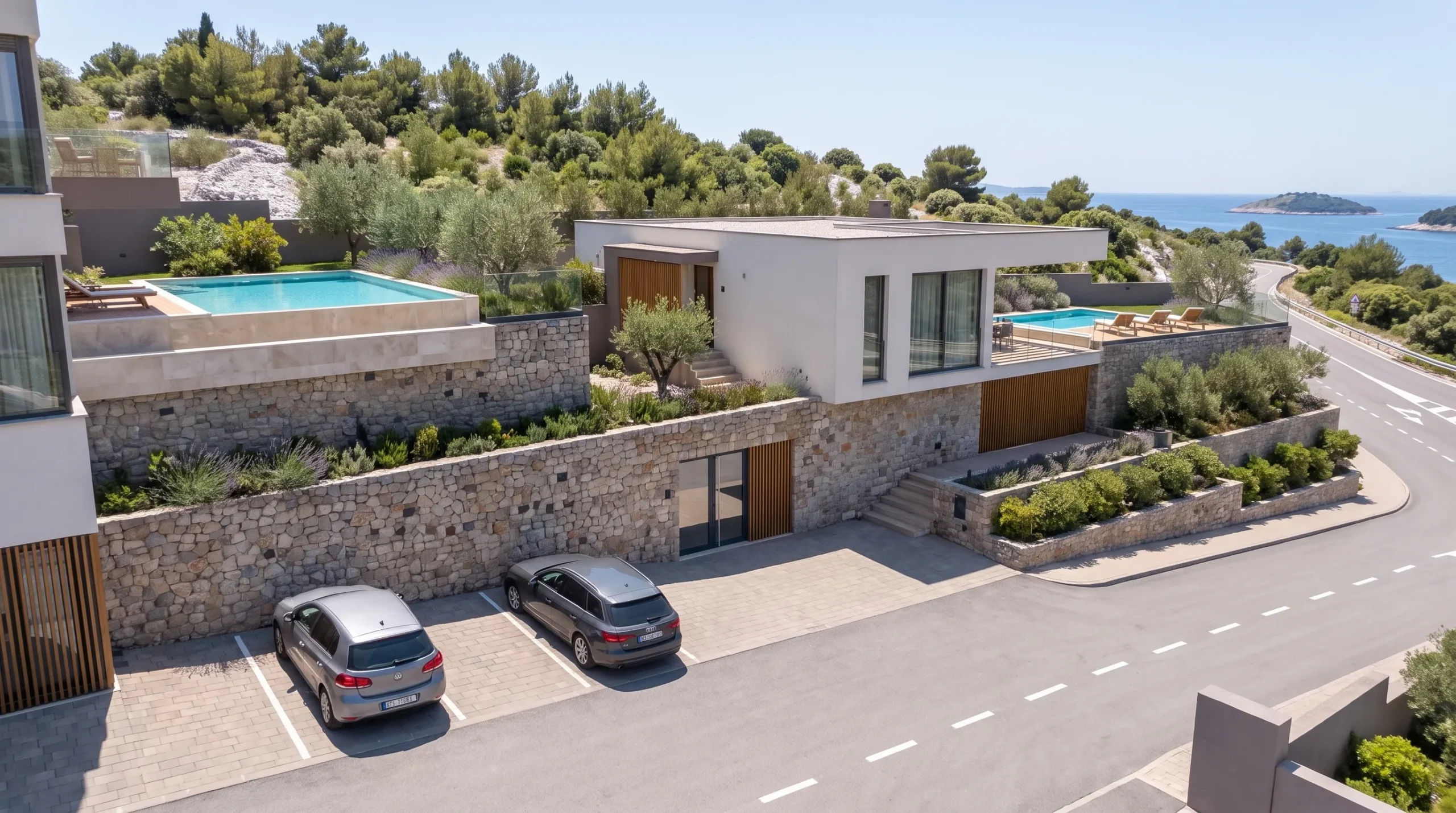 Villa entrance and parking off the coastal road, pool and sea beyond